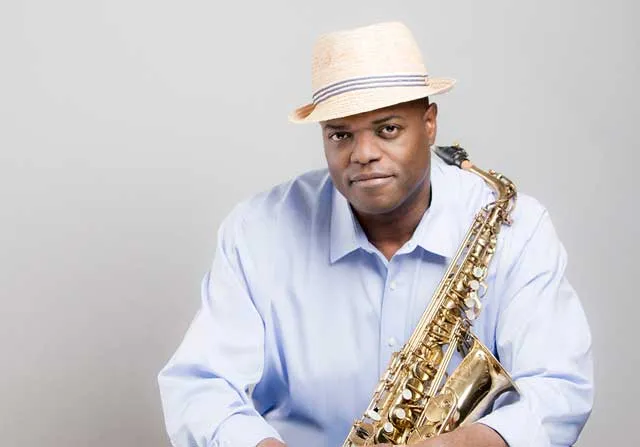 Adaryll Jordan in a straw fedora, holding his alto saxophone